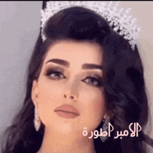 a close up of a woman wearing a tiara with arabic writing on the bottom
