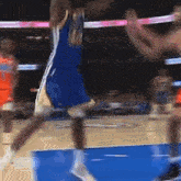 a basketball player in a blue jersey with the number 21 on it is jumping in the air