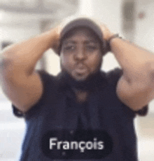 a man wearing a hat and a black shirt with the name francois on it