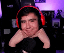 a man wearing red headphones is smiling in front of a youtube logo .