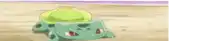 a green pokemon with a yellow hat is crawling on the sand .