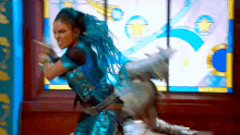 a woman with blue hair is standing in front of a window holding a sword .