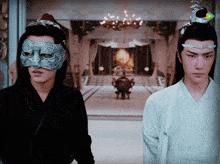 two men wearing masks are standing next to each other in a room