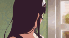 a woman with long black hair looks out a window