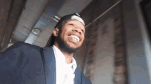 a man in a suit and hat is smiling and looking up
