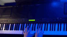a person is playing a keyboard with a blue light behind it