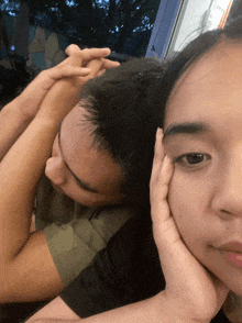 a woman rests her head on a man 's shoulder while he sleeps