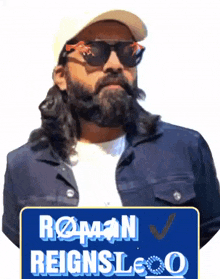 a man wearing sunglasses and a hat holds a sign that says roman reignsloo