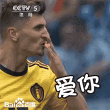 a man in a yellow jersey is blowing a kiss in a foreign language
