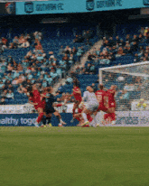 a soccer game is being played in front of a banner that says gotham fc
