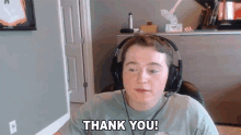 a boy wearing headphones says thank you