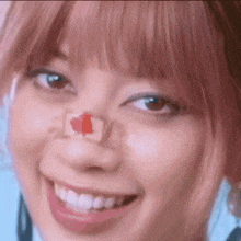 a close up of a woman 's face with a patch on her nose