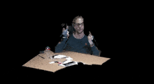 a pixelated image of a man sitting at a table with a book on it