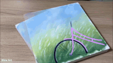 a painting of a pink bicycle is on a wooden table with wow art written below it