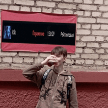 a man drinking a beer in front of a riki banner