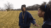 two men are standing in a field and one has a lanyard around his neck that says ' justice ' on it