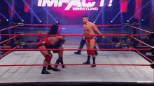 two men are wrestling in a wrestling ring with a sign that says impact wrestling behind them .