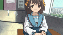 a girl sits at a desk in front of a sign that says " today "