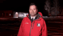 a man wearing a red jacket with ll bean on the sleeve