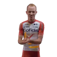 a man wearing a red and white cofidis jersey giving a thumbs up