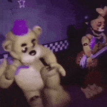 a teddy bear with a purple hat is standing next to another teddy bear in a dark room