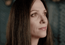 a close up of a woman 's face with long hair and red lipstick