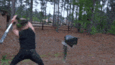 a man is swinging a bat at a mailbox in a forest
