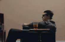 a man sitting in a chair with a glass of beer on a tray