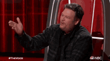 a man sitting in a chair with a nbc logo on the bottom right