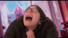 a man with glasses is making a funny face with his mouth wide open