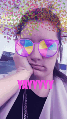 a woman wearing sunglasses with confetti on her face and the words yayyyy on the bottom