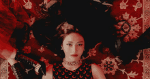 a woman laying on a red rug with a crescent moon on her top