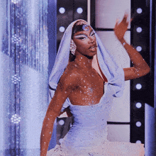 a woman wearing a purple top and a white dress is dancing