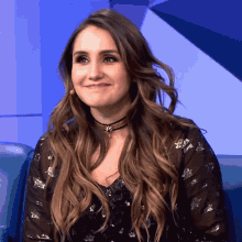 a woman wearing a choker and a black shirt smiles