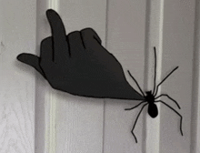 a silhouette of a hand giving a middle finger to a spider .