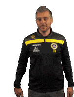 a man wearing a black and yellow shirt with the letters tr on the front