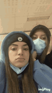 two girls wearing face masks are posing for a picture together