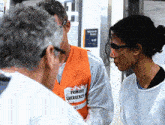 a man in an orange vest that says primary emergency