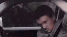 a man in a suit is sitting in the back seat of a car .