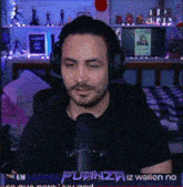 a man wearing headphones is sitting in front of a microphone with the words fuanza iz wallen no on the screen