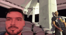 a man with a beard is taking a selfie with another man