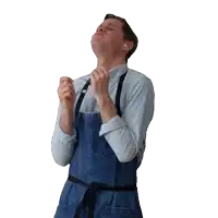 a man wearing a blue apron is looking up