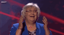 a woman with glasses and a watch is covering her mouth with her hand