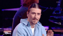 a man in a blue shirt is sitting in front of a purple background with the word star academy on it