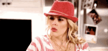 a woman is wearing a red hat and a striped shirt