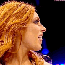 a close up of a woman with red hair sticking her tongue out .