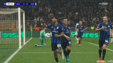 a group of soccer players are celebrating a goal in front of a sign that says eres