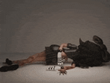 a person is laying on the floor with a bottle of water in their hand and sleeping .