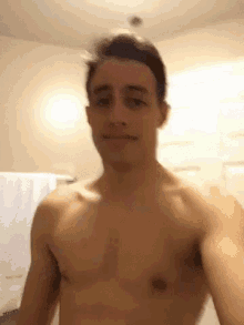 a shirtless man is taking a selfie in a bathroom