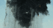 a plane flying through a cloud of smoke and fire